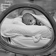 Baya participe au concours pour gagner de l'argent avec cette photo : baby, bed, blanket, child, closeup, face, fragile, head, healthcare, hospital, incubator, infant, medical_equipment, monochrome, nasal_tube, newborn, patient, person, sleeping, wrapped