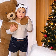 Lëyah participe au concours pour gagner de l'argent avec cette photo : baby, bodypart, christmas, christmasdecorations, christmastree, clothing, face, festival, finger, fir, hand, happy, hat, head, person, plant, shorts, smile, teddybear, toy