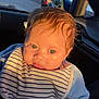 baby, child, infant, striped_bib, car_interior, tattoo, hand, sunlight, blue_clothing, closeup, face, cute, portrait, person, seat, window, reflection, skin, hair, car