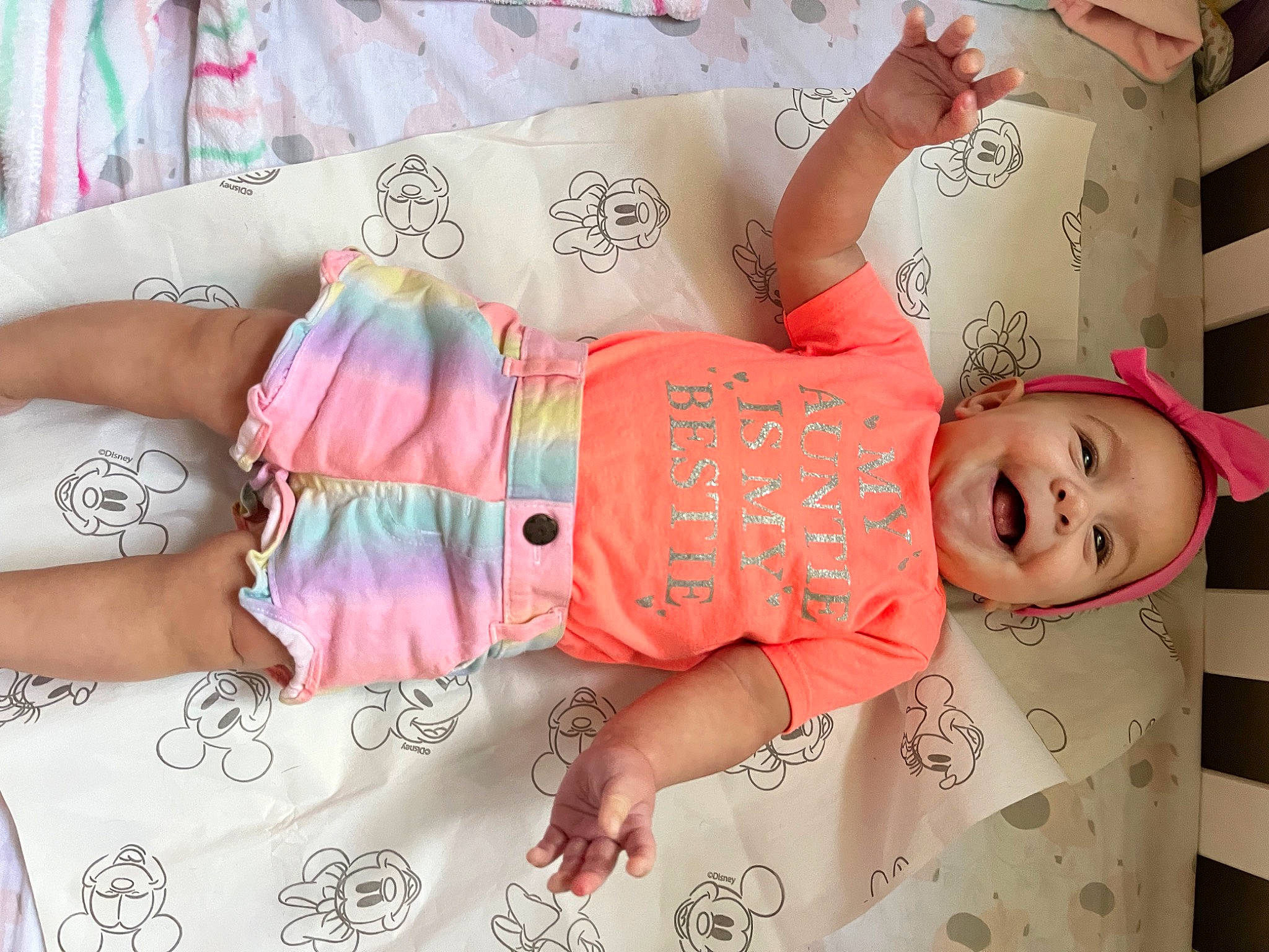 Harper is registered to the contest to win money with this photo: abdomen, baby, baby_toddler_clothing, child, font, hand, happy, headwear, human_leg, joy, linens, magenta, nail, pattern, peach, person, pink, room, skin, sleeve