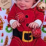 baby, infant, smiling, red_clothing, holiday_outfit, christmas_theme, festive, ornaments, blanket, patterned_blanket, wooden_sign, five_months, face, hands, cute, lying_down, holiday_decor, seasonal, child, happy