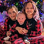 child, children, baby, christmas_tree, holiday, pajamas, plaid, smile, happy, family, indoor, floor, wood_floor, decorations, lights, festive, celebration, sitting, together, love