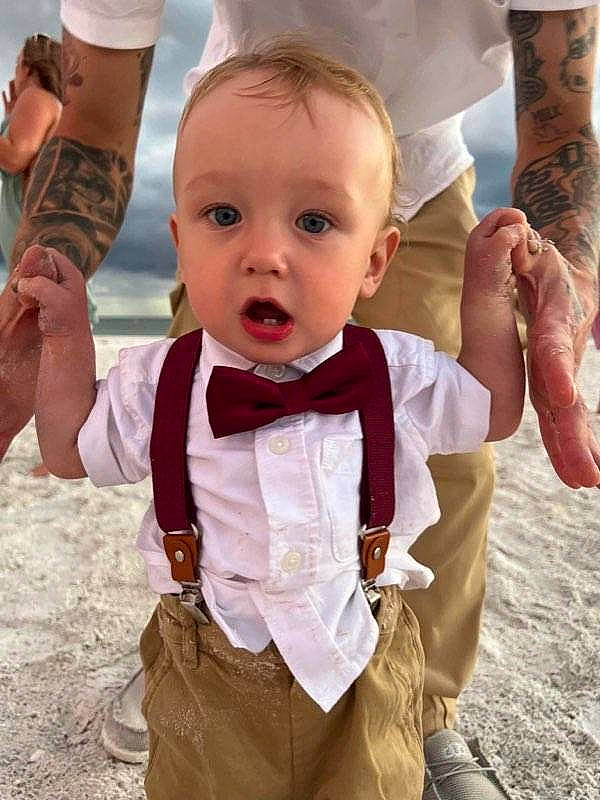 Aydin is registered to the contest to win money with this photo: baby, baby_toddler_clothing, child, event, finger, formal_wear, fun, gesture, hand, happy, joint, people_in_nature, person, pink, sand, skin, sleeve, surprise, thumb, toddler