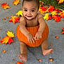 baby, pumpkin, autumn_leaves, fall, outdoor, child, smiling, concrete, seasonal, cute, holiday, nature, orange, yellow, red, barefoot, sitting, festive, happy, portrait