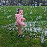 toddler, child, bubbles, grass, outdoor, field, jacket, leopard_print, pants, shoes, playful, curious, nature, daylight, person, fun, activity, green, casual_clothing, young