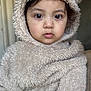 animal_theme, baby, beige, child, close_up, costume, cute, expressionless, eyes, face, fur, furry_clothing, headwear, hood, indoor, person, portrait, soft_texture, toddler, warm