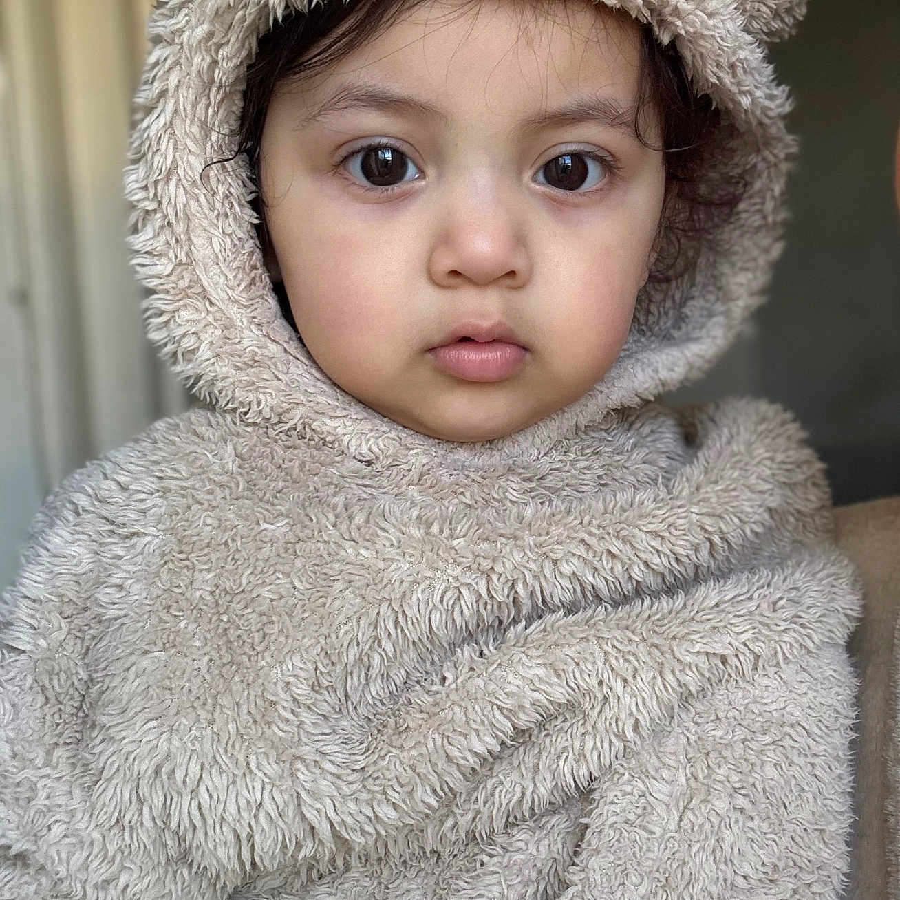Yavik is registered to the contest to win money with this photo: animal_theme, baby, beige, child, close_up, costume, cute, expressionless, eyes, face, fur, furry_clothing, headwear, hood, indoor, person, portrait, soft_texture, toddler, warm