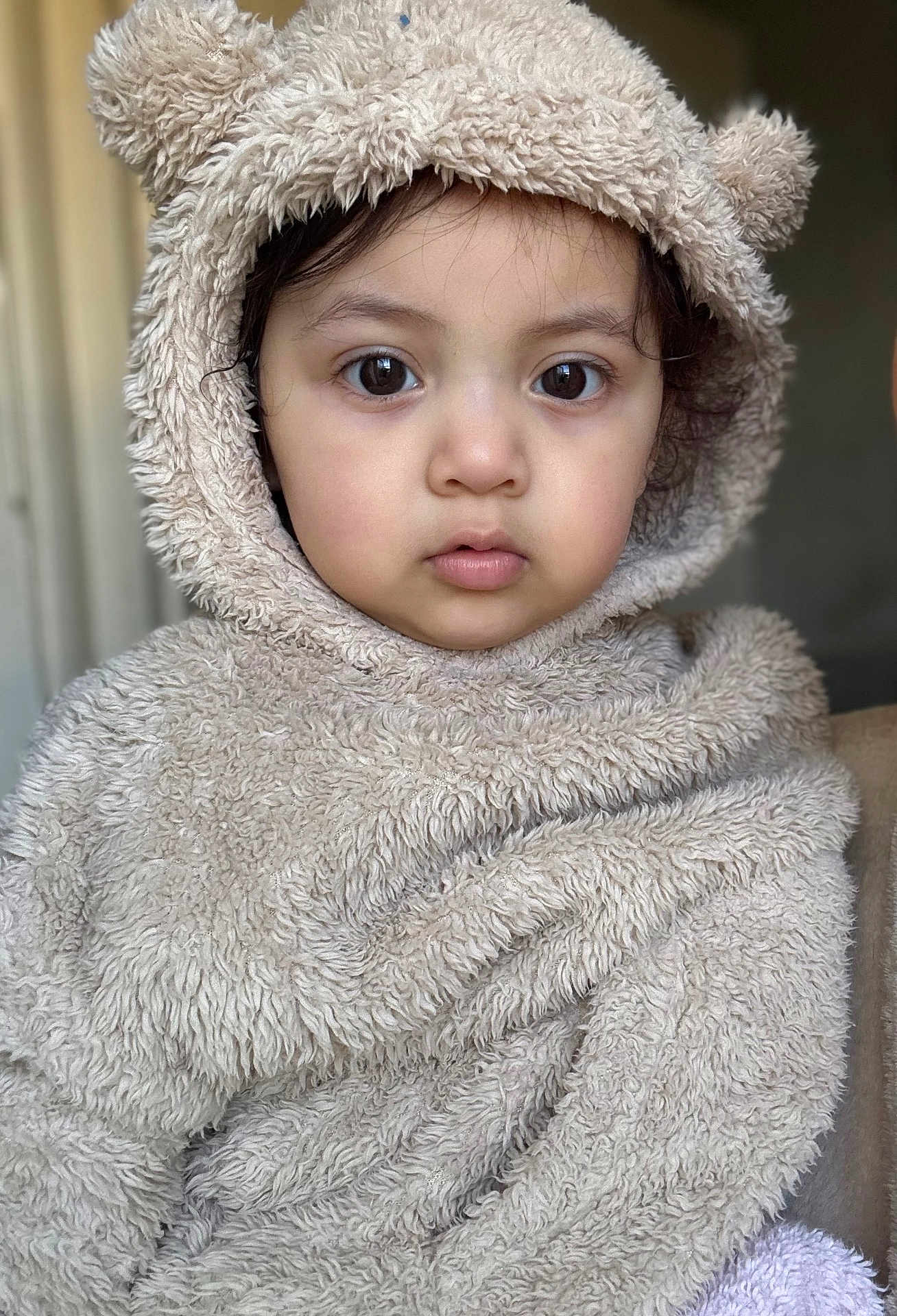 Yavik is registered to the contest to win money with this photo: animal_theme, baby, beige, child, close_up, costume, cute, expressionless, eyes, face, fur, furry_clothing, headwear, hood, indoor, person, portrait, soft_texture, toddler, warm