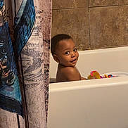 Nyairr joined the competition — help win amazing prizes! bath_mat, bath_time, bathroom, bathtub, child, curious, cute, face, home, indoor, playful, portrait, shower_curtain, skin, smiling, tile_wall, toddler, toy, water, young_child