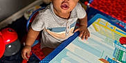 Nyairr joined the competition — help win amazing prizes! baby, carpet, chair, child, colorful, curious, expression, eyes, face, floor, furniture, hand, indoor, person, playroom, room, shirt, table, toddler, toy