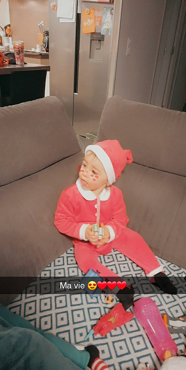 Léana a rejoint le concours — aidez-le/la à gagner de superbes lots ! baby, cap, carmine, child, christmas, christmas_eve, comfort, couch, event, fictional_character, flooring, fun, hat, headwear, holiday, lap, living_room, person, room, santa_claus