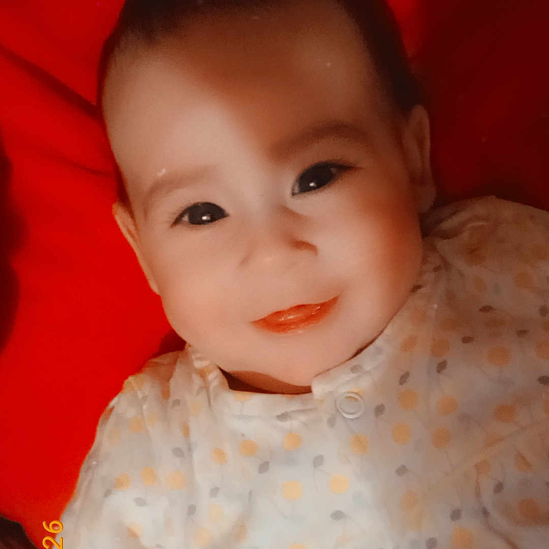 Ilyana a rejoint le concours — aidez-le/la à gagner de superbes lots ! baby, smiling, face, infant, child, polka_dot, clothing, red_background, portrait, cute, closeup, happy, young, soft_light, indoor, person, lying_down, baby_garment, warm_color, adorable