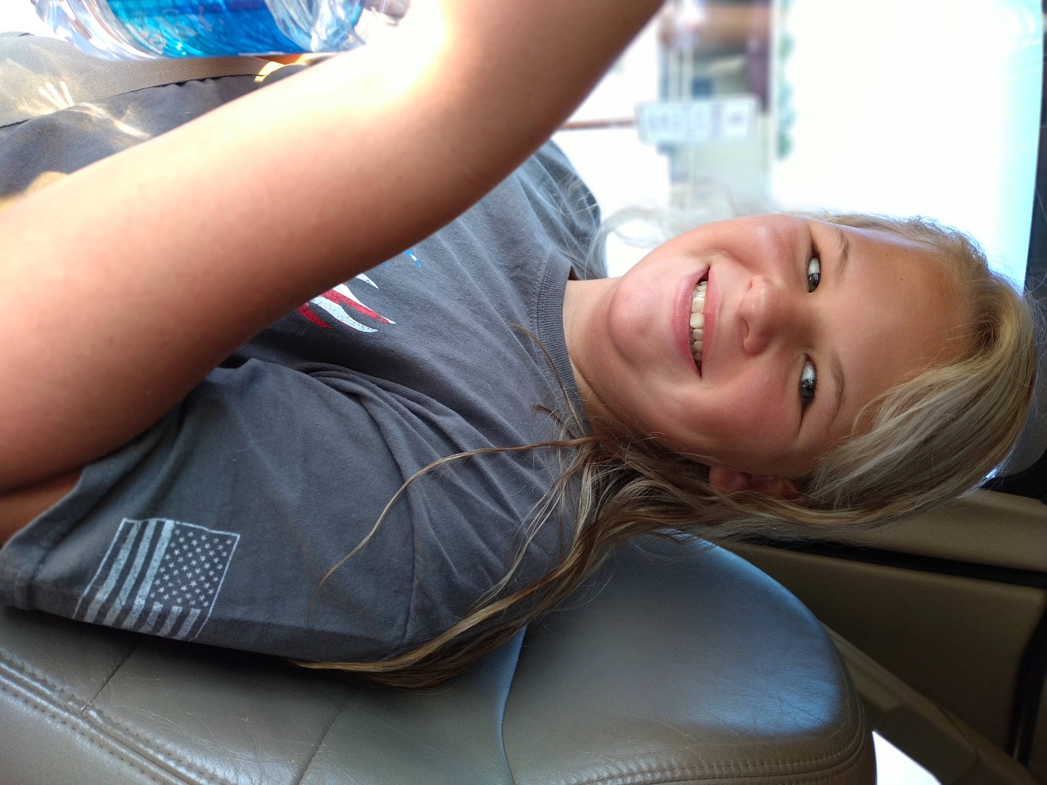 Dixie is registered to the contest to win money with this photo: automotive_design, black_hair, comfort, elbow, eyewear, facial_expression, gesture, hairstyle, happy, human_leg, joint, joy, leg, leisure, mammal, motor_vehicle, mouth, person, shoulder, smile