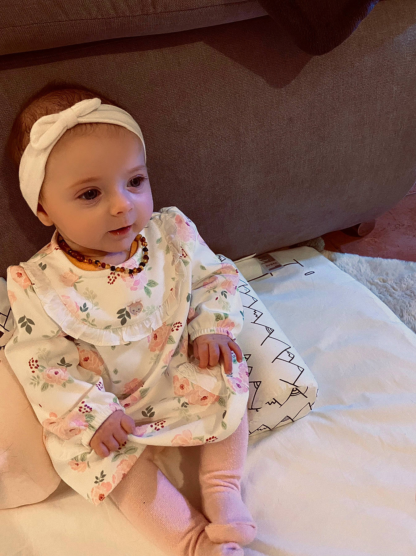 Luisa participe au concours pour gagner de l'argent avec cette photo : baby, baby_toddler_clothing, cap, cheek, child, comfort, dress, fashion_accessory, fashion_design, flooring, fun, happy, jewellery, necklace, pattern, peach, person, sitting, sleeve, toddler