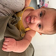 Alizée participe au concours pour gagner de l'argent avec cette photo : adult, arm, baby, background, casual, child, clothing, cute, expression, face, gray_top, green_pants, hand, holding, home, indoor, person, playful, skin, tongue_out