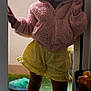 Jade participe au concours pour gagner de l'argent avec cette photo : child, toddler, hoodie, pink, yellow_shorts, plush_slippers, doorway, indoor, smile, curly_hair, standing, playful, casual_clothing, footwear, soft_lighting, green_carpet, bucket, toy, shadow, cozy