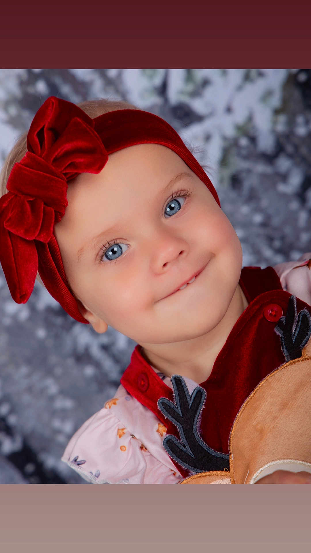 Raven is registered to the contest to win money with this photo: toddler, child, blue_eyes, red_headband, velvet_bow, smiling, face, portrait, holiday_clothing, festive, cute, winter_background, reindeer, button, pink_dress, baby, innocent, young_child, close_up, happy