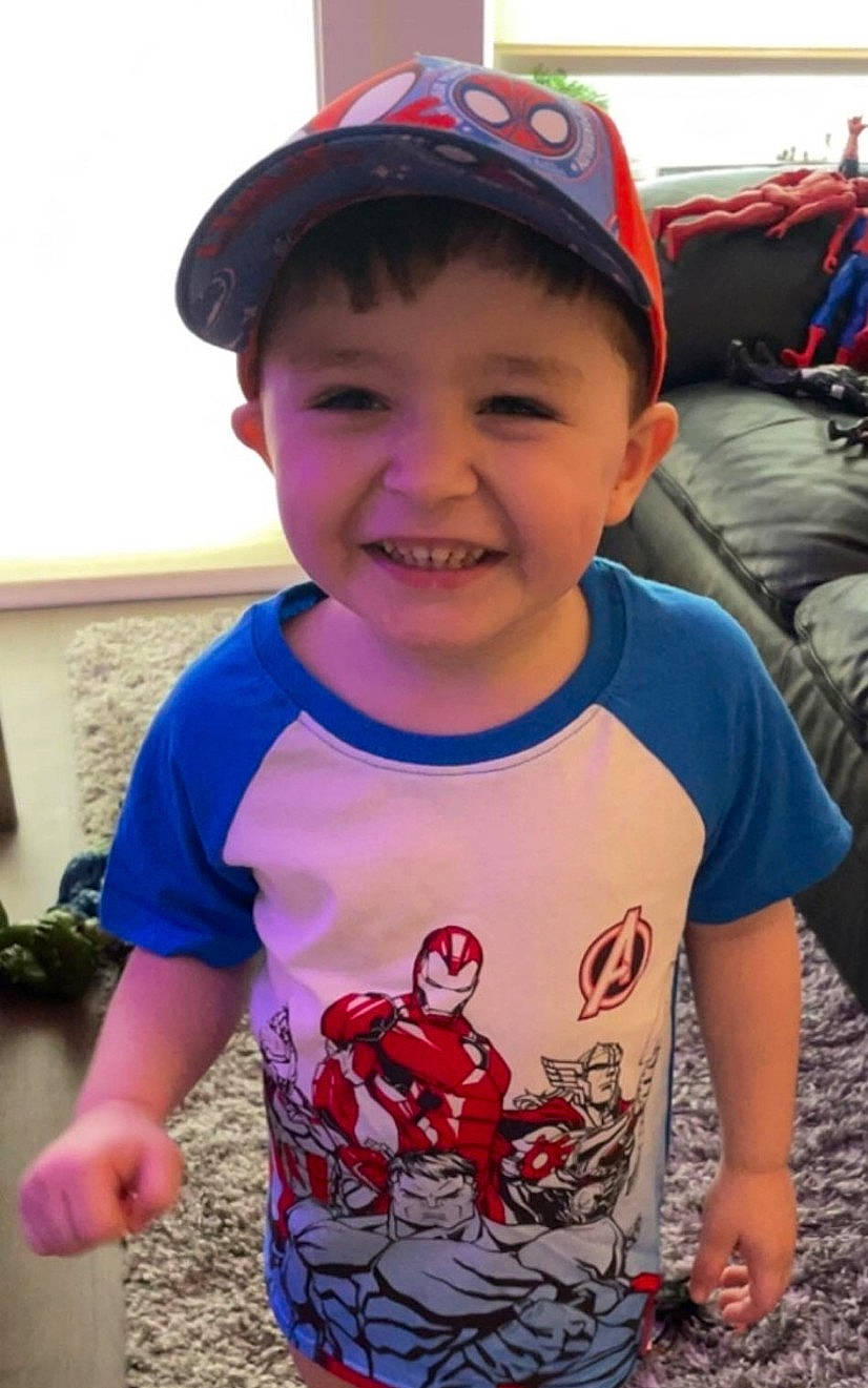 Kian is registered to the contest to win money with this photo: baby, baby_toddler_clothing, baseball_cap, cap, cheek, cool, fun, happy, hat, head, joy, neck, person, plant, red, skin, sleeve, smile, standing, summer