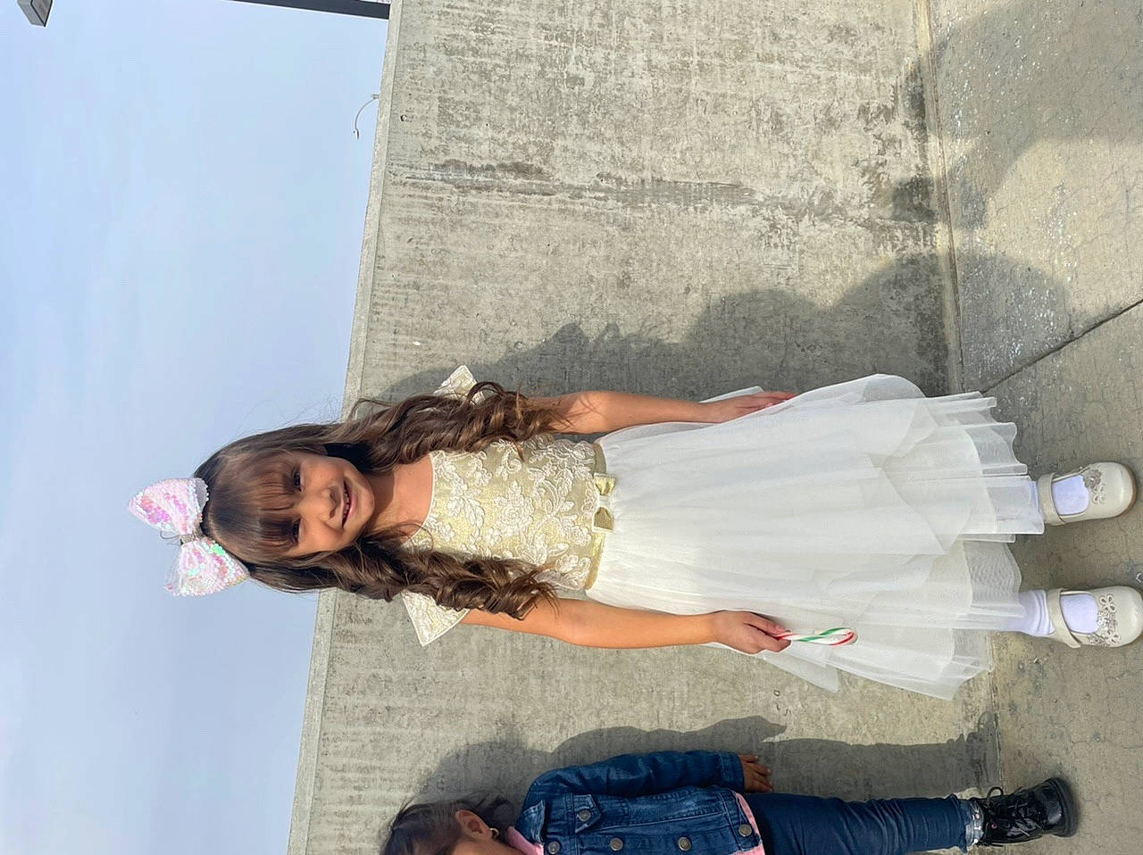 Zendaya is registered to the contest to win money with this photo: blurred, concrete, eyewear, fun, happy, human_leg, joy, knee, leisure, person, sandal, sitting, sky, smile, thigh, travel, under_exposed, waist