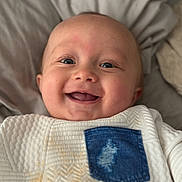 Forrest joined the competition — help win amazing prizes! baby, smiling, face, blue_eyes, white_clothing, denim_pocket, blanket, texture, infant, happy, cute, child, portrait, closeup, skin, lying_down, young, indoors, soft_light, expression