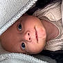 Forrest is registered to the contest to win money with this photo: baby, face, eyes, blanket, knitwear, sweater, closeup, infant, child, soft_texture, warm, cozy, portrait, cute, skin, head, looking, indoors, person, newborn