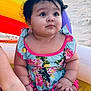 Amelia joined the competition — help win amazing prizes! baby, child, swimsuit, inflatable_pool, beach, sand, water, colorful, floral_pattern, pink, curly_hair, summer, outdoor, cute, chubby, sitting, playful, sunlight, infant, vacation