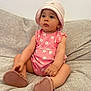 Leyna participe au concours pour gagner de l'argent avec cette photo : baby, casual, child, clothing, comfortable, couch, cute, footwear, hat, home, indoor, infant, person, pink_onesie, portrait, relaxed, sitting, soft_lighting, toddler, young_child