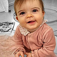 Louane a rejoint le concours — aidez-le/la à gagner de superbes lots ! baby, infant, smiling, portrait, indoor, pink_clothes, onesie, big_eyes, hands, toy, playtime, blanket, floor, nursery, seat, curtain, close_up, cute, collar, cheerful