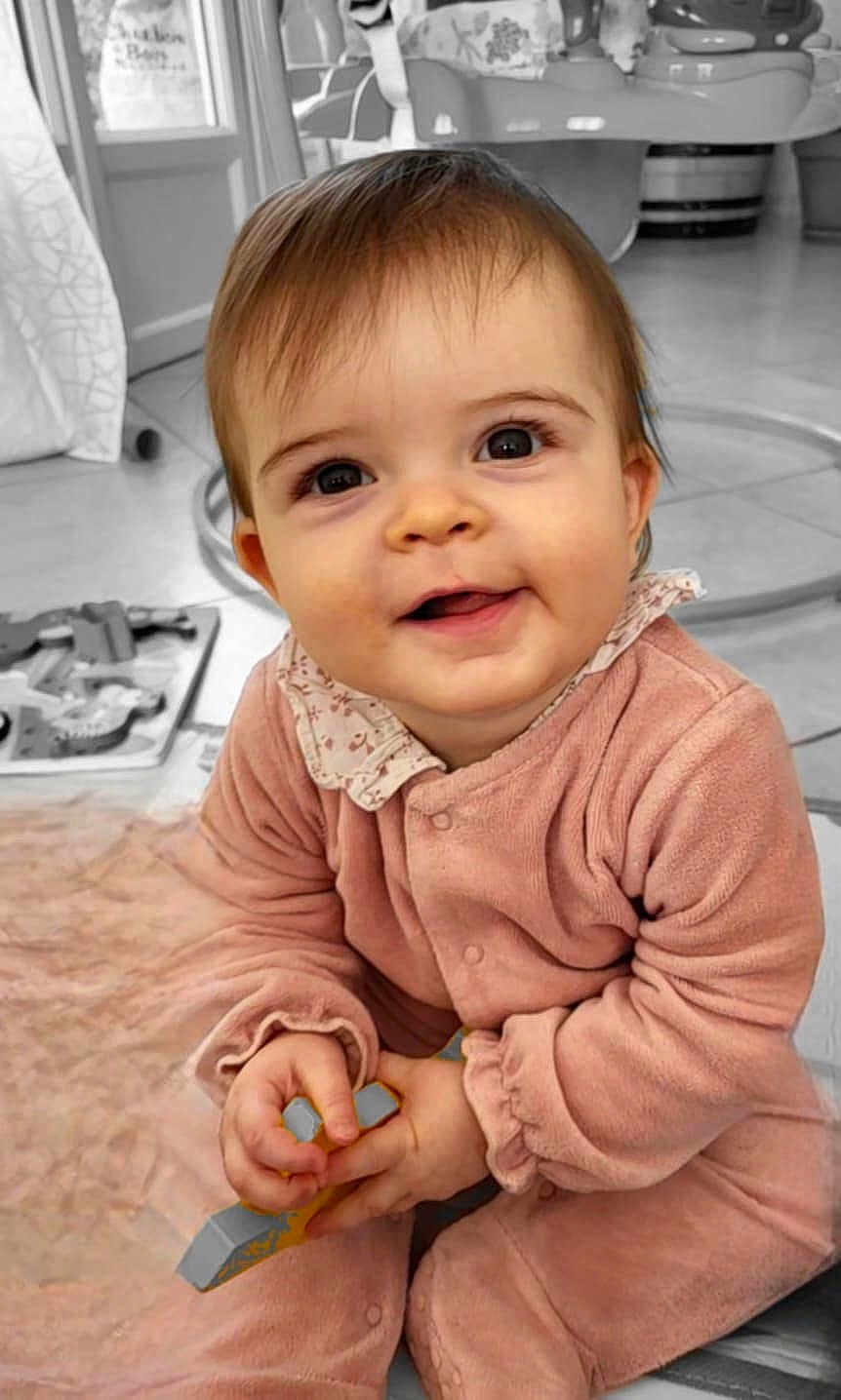 Louane a rejoint le concours — aidez-le/la à gagner de superbes lots ! baby, infant, smiling, portrait, indoor, pink_clothes, onesie, big_eyes, hands, toy, playtime, blanket, floor, nursery, seat, curtain, close_up, cute, collar, cheerful