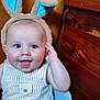 baby, bunny_ears, smiling, blue_eyes, basket, toys, wooden_background, striped_clothing, happy, infant, cute, child, indoor, plush, face, headgear, playful, seated, person, portrait