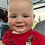 Graesyn is registered to the contest to win money with this photo: baby, child, smiling, drool, red_shirt, clip, bald_head, face, person, outdoor, tent, hair_tie, adult_hand, happy, closeup, cheeks, skin, eyes, mouth, clothing