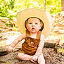 Graesyn is registered to the contest to win money with this photo: baby, child, hat, cowboy_hat, overalls, sitting, water, riverbank, sand, outdoor, nature, sunlight, reflection, barefoot, curious, portrait, cute, summer, greenery, daylight