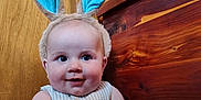 Graesyn joined the competition — help win amazing prizes! baby, basket, blue_ears, bunny_ears, child, chubby_cheeks, closeup, cute, face, happy, indoors, infant, playful, plush, portrait, sitting, smile, striped_clothing, toy, wooden_background