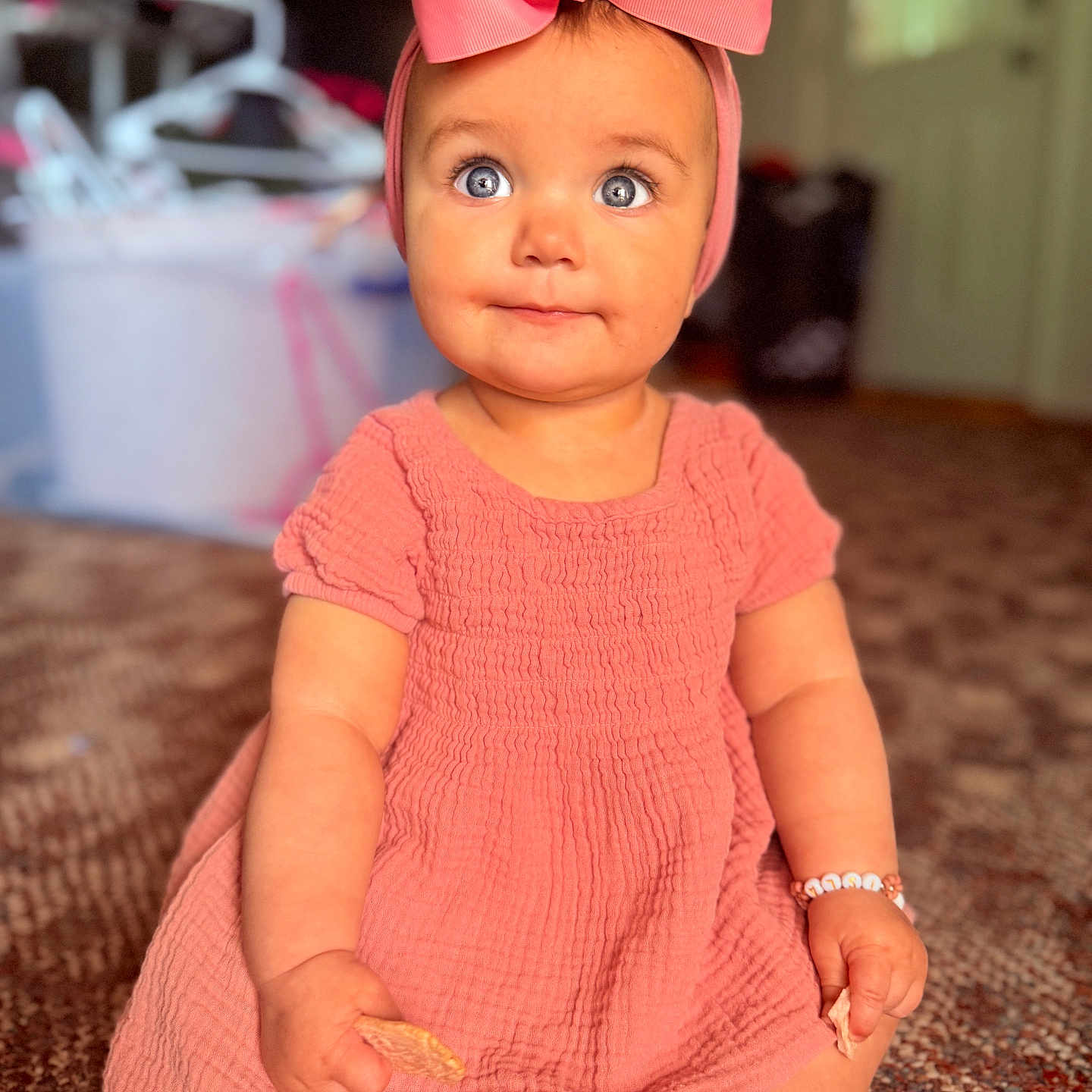 Isla is registered to the contest to win money with this photo: accessories, baby, bodypart, clothing, couch, dress, eveningdress, face, finger, formalwear, furniture, hand, hardwood, hat, head, jewelry, person, photography, portrait, wood