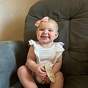 Mayci joined the competition — help win amazing prizes! baby, child, smile, headband, pink_bow, striped_outfit, chair, gray_chair, plush, happy, tongue_out, cute, indoor, person, infant, sitting, wooden_sign, skin, face, young_child