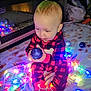 baby, child, pajamas, red, black, checkered, christmas_lights, ornament, blue, blanket, holiday, festive, indoors, floor, cute, toddler, sitting, toy, decorations, warm