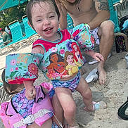 Lilyana joined the competition — help win amazing prizes! child, toddler, beach, sand, floaties, swimwear, disney_princess, umbrella, lounge_chair, tattoo, man, smile, happy, summer, vacation, outdoor, water_safety, family, play, footwear