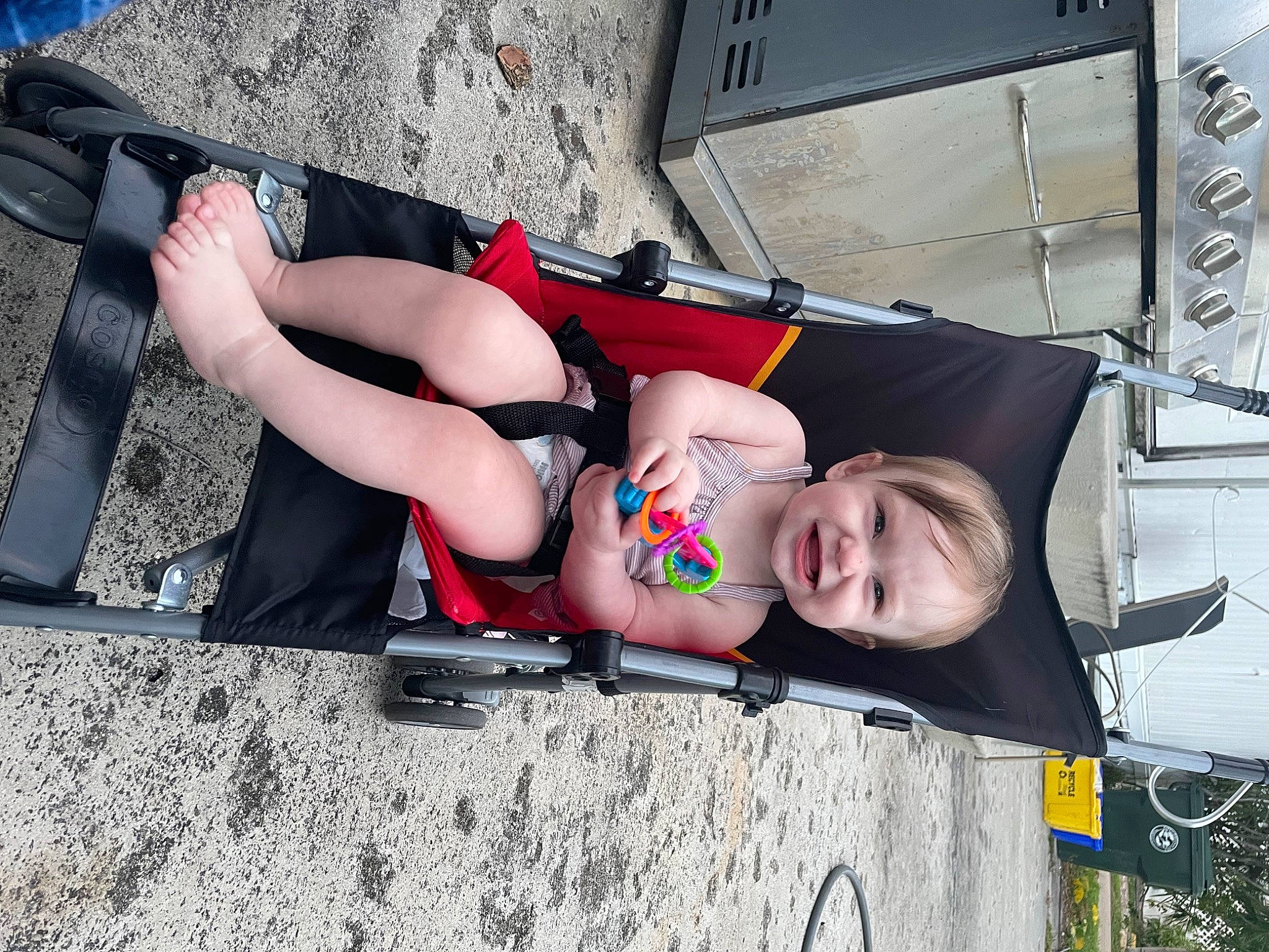 Lilah is registered to the contest to win money with this photo: abdomen, ankle, auto_part, calf, carmine, chest, elbow, eyewear, flesh, foot, human_leg, joy, knee, person, sandal, shorts, sitting, smile, thigh, tire