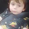 child, car_seat, seatbelt, vehicle, shirt, patterned_clothing, boy, indoors, casual, young, portrait, seat, car_interior, child_seat, transportation, safety, neutral_expression, hair, person, clothing