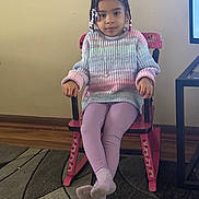 Reign joined the competition — help win amazing prizes! child, girl, braided_hair, beads, sweater, leggings, rocking_chair, pink_chair, indoor, carpet, wood_floor, wall, furniture, portrait, sitting, crossed_legs, calm, casual_clothing, young, home