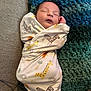 newborn, baby, sleeping, swaddled, blanket, zebra, giraffe, pillow, couch, cozy, infant, resting, peaceful, soft, cute, pattern, animal_print, homedecor, indoors, child