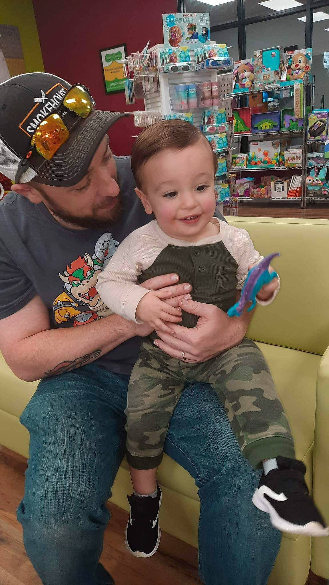Corbin joined the competition — help win amazing prizes! arm, baby, baseball_cap, cap, child, clothing, event, fun, happy, headwear, jeans, joy, lap, leg, leisure, person, shelf, shorts, skin, smile