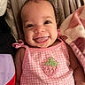 baby, child, smile, tongue_out, pink_clothing, bow, strawberry_patch, blanket, soft_fabric, cute, portrait, happy, infant, lying_down, indoors, face, head, cheerful, closeup, person