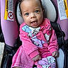 baby, child, car_seat, pink, clothing, cute, smiling, happy, portrait, indoors, infant, bow, person, seatbelt, cartoon, apparel, face, headwear, footwear, sitting