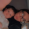 baby, adult, glasses, selfie, indoor, child, person, face, portrait, curious, closeup, arm, window, light, black_clothing, skin, hair, expression, young, candid