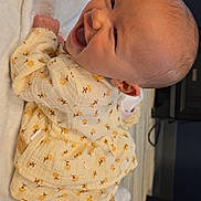 Jalynn joined the competition — help win amazing prizes! baby, smiling, infant, yellow_clothing, floral_pattern, socks, blanket, indoor, happy, cute, lying_down, head, face, skin, person, child, toddler, cozy, warm, soft_texture