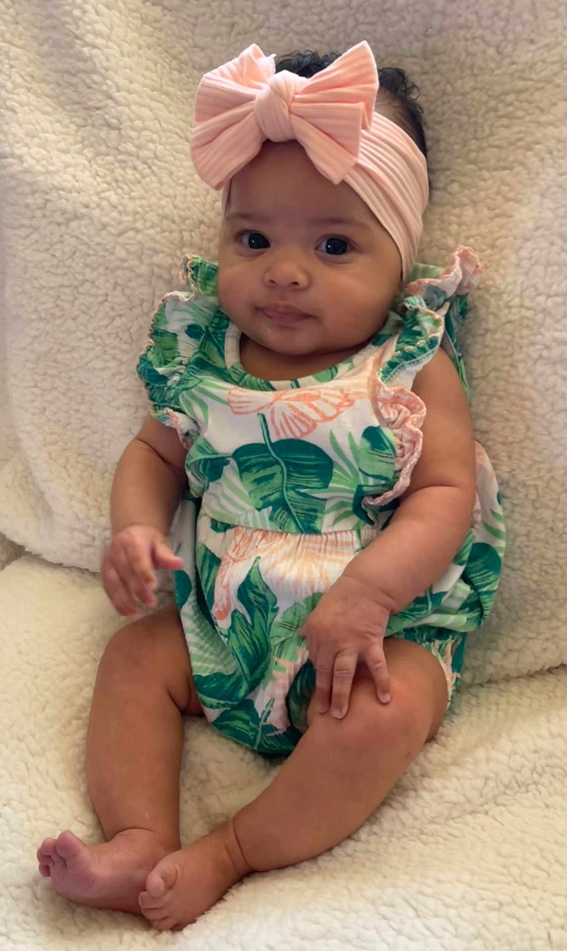 Nylah is registered to the contest to win money with this photo: baby, infant, child, headband, pink_bow, romper, leaf_pattern, sitting, blanket, fluffy, cute, portrait, indoors, soft_texture, skin, feet, hands, expression, young, adorable