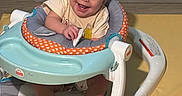 Koa is registered to the contest to win money with this photo: baby, walker, smiling, indoor, child, seat, happy, toy, floor, feet, clothing, person, infant, play, cute, face, expression, home, sitting, young