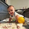baby, smiling, crawling, crib, yellow_ball, bedspread, winnie_the_pooh, indoor, child, happy, toy, infant, cute, person, furniture, wooden_crib, playtime, portrait, toddler, clothing