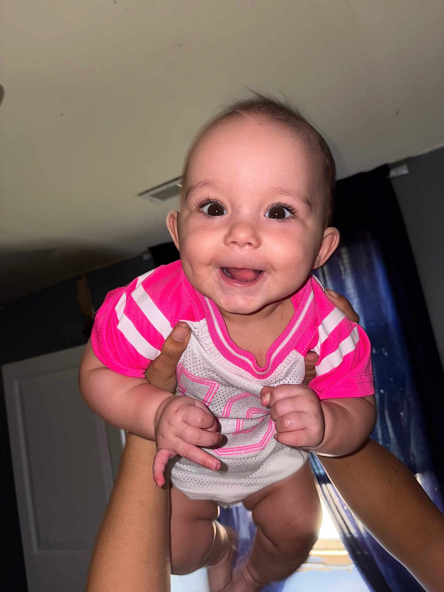 Vanessa joined the competition — help win amazing prizes! baby, child, smile, happy, face, person, arms, hands, indoors, curtains, window, clothing, pink, white, skin, portrait, cute, infant, joy, holding